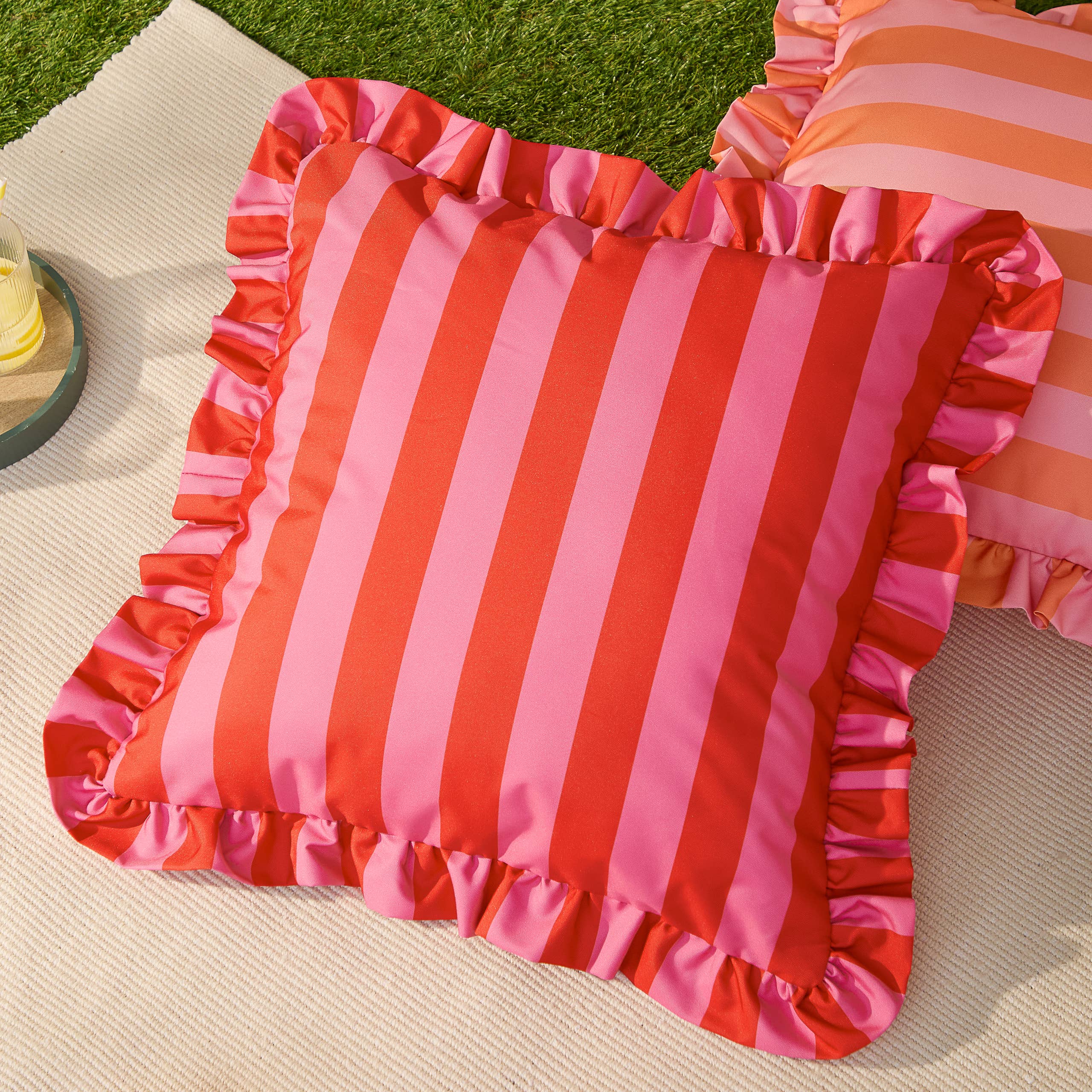 Coussin d'extérieur imprimé à volants Palm Royale Stripe Rose/Rouge